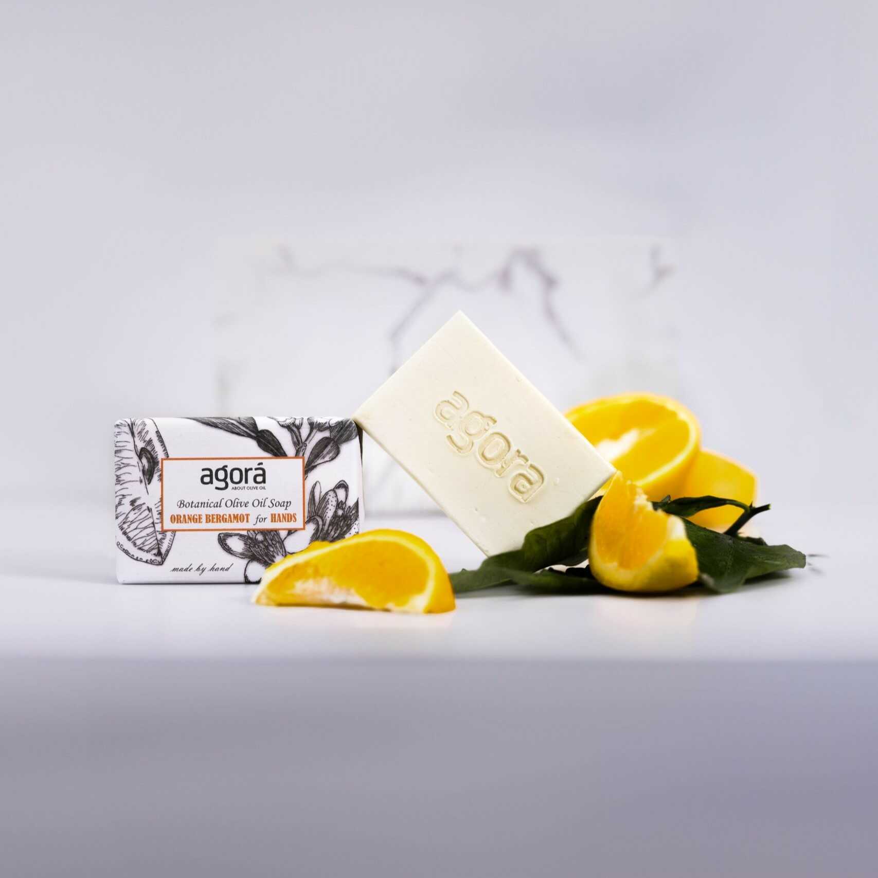 Handcrafted olive oil soap with orange and bergamot by Agorá, surrounded by fresh orange slices. Natural and eco-friendly skincare from Greece.